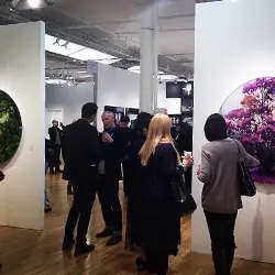 A group of people standing around in an art gallery.